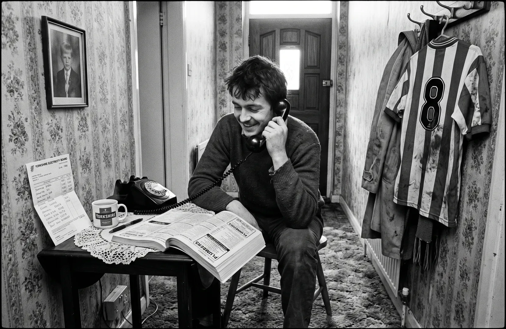 Barry's hallway, Doncaster, 1986. Phone table with doily, Yellow Pages, confirmation photo, Doncaster Rovers shirt.